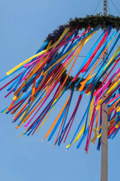 Maypole with colourful ribbons on a sunny spring May Day in Europe