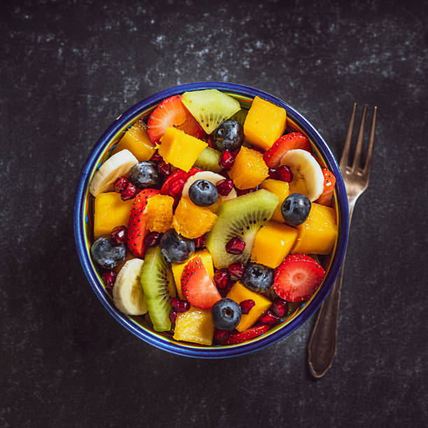 tigela de salada de frutas caseira saudável shot de cima. - healthy eating multi colored orange above - fotografias e filmes do acervo