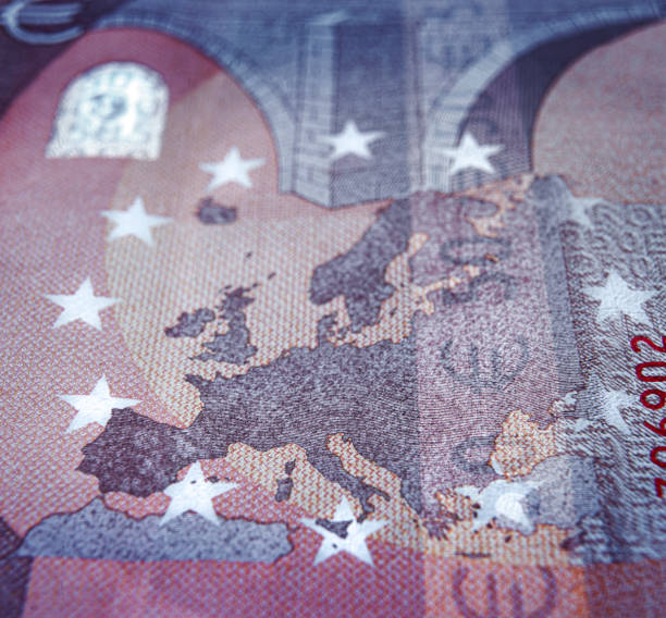 Europe map detail of euro bill Shallow focus against euro banknote focused on europe map european union currency european union euro note currency europe stock pictures, royalty-free photos & images