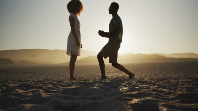 African American man proposing wedding at beach
