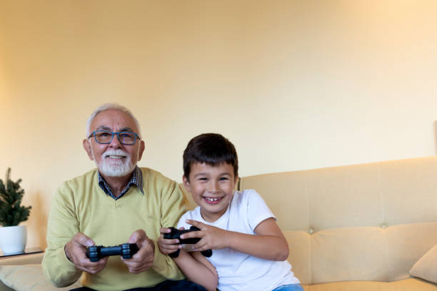 istock Handsome Grandpa and Grandson are Playing Game Console While Spending Time Together at Home. 1225983577