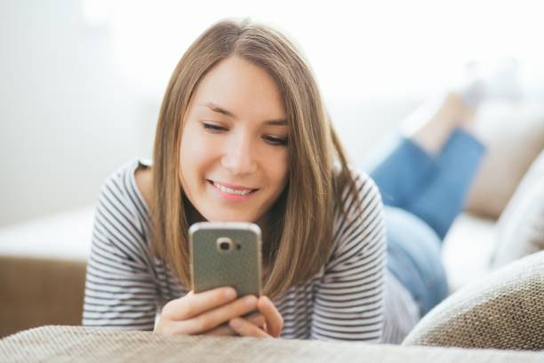 istock Beautiful young caucasian woman on  sofa using cell phone 1225983640