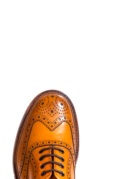 Extreme Closeup of Medalion of One Separate Male Tan Brogue Oxford Shoe. Isolated Over White Background. Vertical Shot Extreme Closeup of Medalion of One Separate Male Tan Brogue Oxford Shoe. Isolated Over White Background. Vertical Shot brogue photos stock pictures, royalty-free photos & images