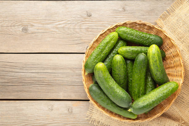 istock Fresh cucumbers in basket on grey background. 1225991596