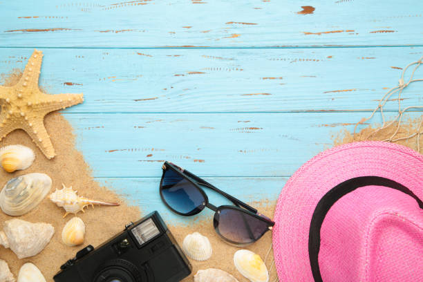 istock Beach hat with seashells and sand on blue background 1225991641