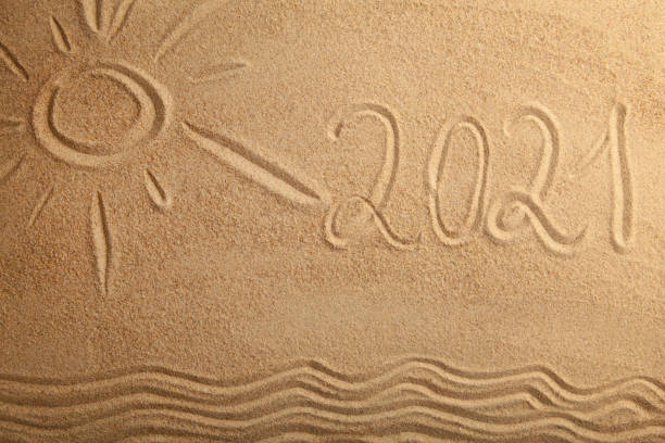 2021 new year text with sun on sand background