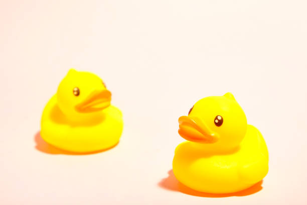 istock Yellow rubber ducks organized on pink background. 1225992099