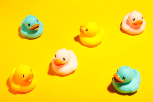 istock Collection of colorful rubber ducks on a yellow background 1225992152