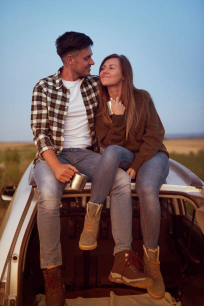 istock Front view of loving couple sitting on a car. 1225992237