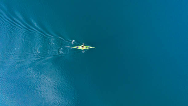 un dron disparando a un kayak flotando en el lago - kayak canoeing canoe lake fotografías e imágenes de stock