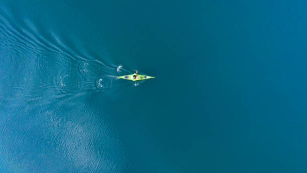A drone shooting a kayak floating in lake A drone shooting a kayak floating in lake canoe photos stock pictures, royalty-free photos & images
