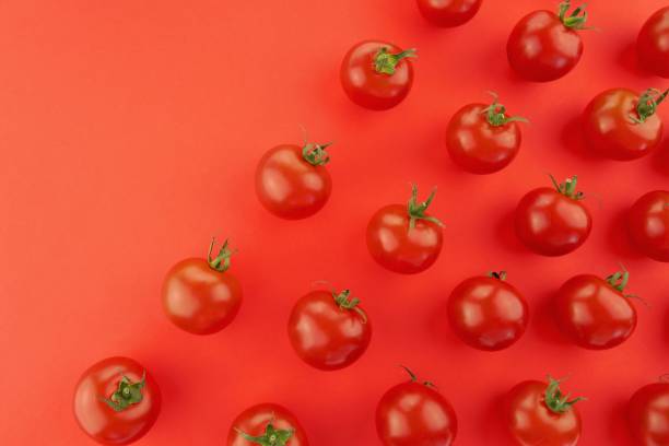 istock Tomato pattern. Tomato background. Red ripe tomatoes on a red background. Tomatoes season vegetables. Farm organic vegetables 1225995504