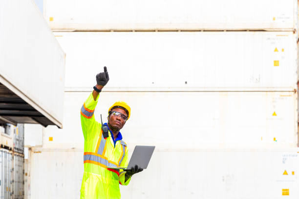 istock Foreman using laptop computer in the port of loading goods. Foreman showing thumbs up on Forklifts in the Industrial Container Cargo freight ship. 1225996168
