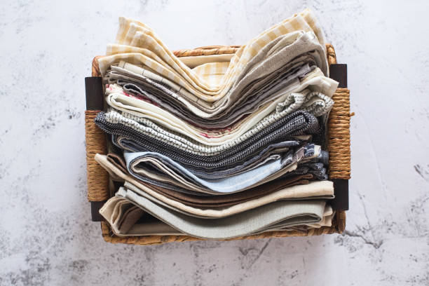 istock kitchen textile. stack of fabrics in different colors and textures, close-up. Kitchen towels on white background. Many fabric kitchen napkins in a wicker basket. Props for food photography