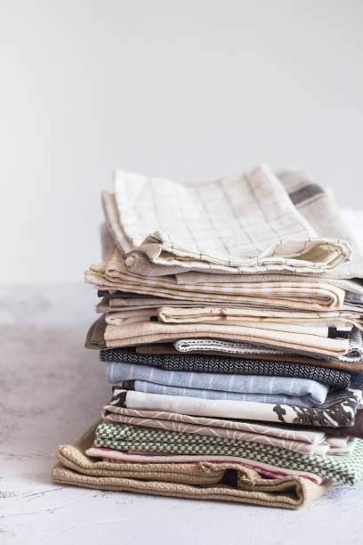 istock kitchen textile. stack of fabrics in different colors and textures, close-up. Kitchen towels on white background. Many fabric kitchen napkins in a wicker basket. Props for food photography