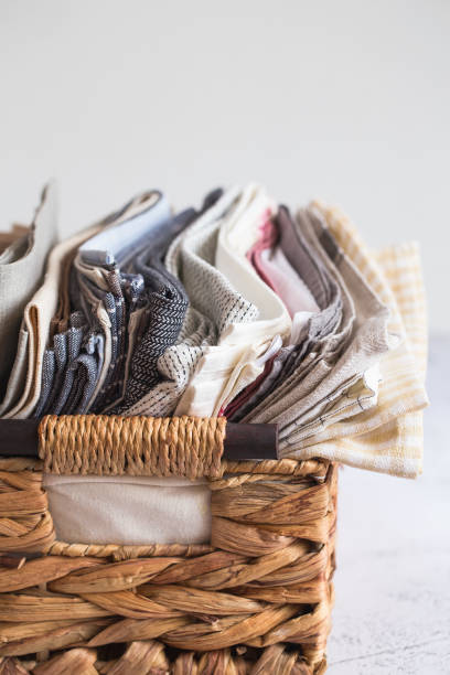 istock kitchen textile. stack of fabrics in different colors and textures, close-up. Kitchen towels on white background. Many fabric kitchen napkins in a wicker basket. Props for food photography