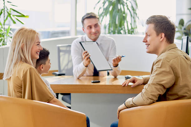 istock smiling salesman waiting for clients, they should sign the document 1225999955