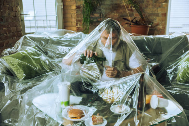 istock Senior man covered with plastic, eating fast food and drinking beer - environmental pollution by people concept 1226001878