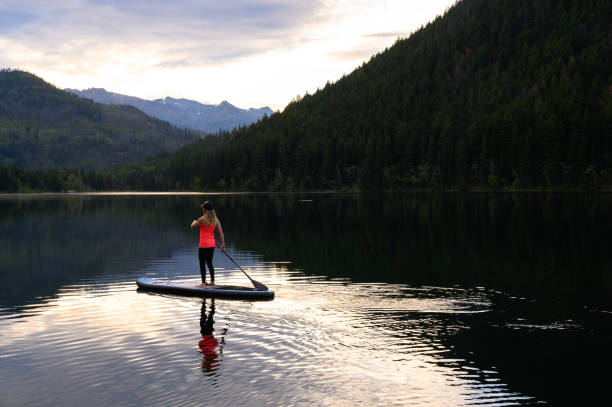 istock Woman stand up paddle boarding on a pristine mountain lake 1226004436