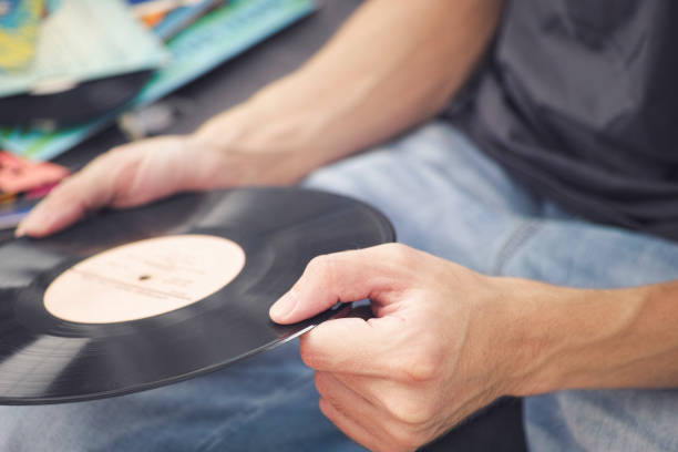 istock Man holding old vinyl record in his hands 1226004519
