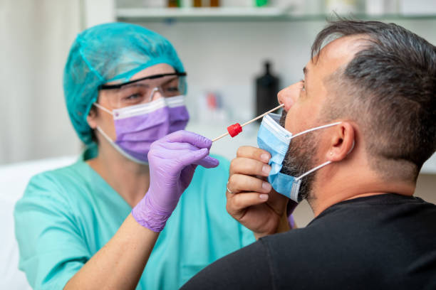 istock Nurse wearing protective workwear taking nose swab test 1226004821