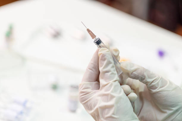 istock Hand in protective glove holding syringe for vaccination against COVID-19 1226004948