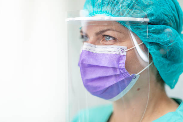istock Female doctor wearing protective mask and visor 1226005896