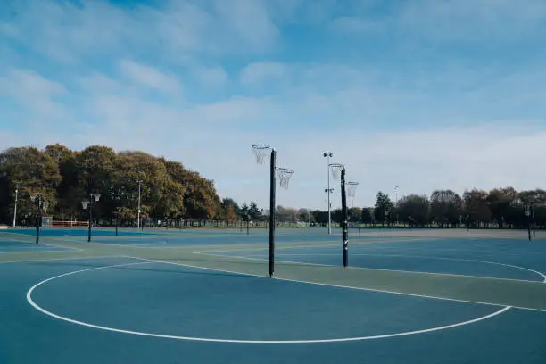 Netball goal ring and net against a blue sky and clouds at Hagley park, Christchurch, New zealand.