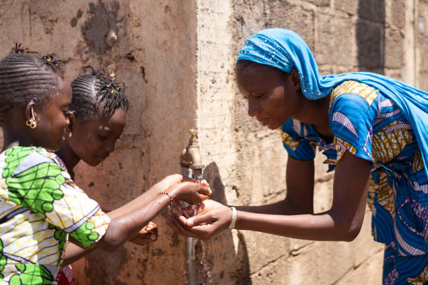 tre splendide ragazze africane intorno a un rubinetto per prendere un po 'd'acqua - africa south africa child african culture foto e immagini stock