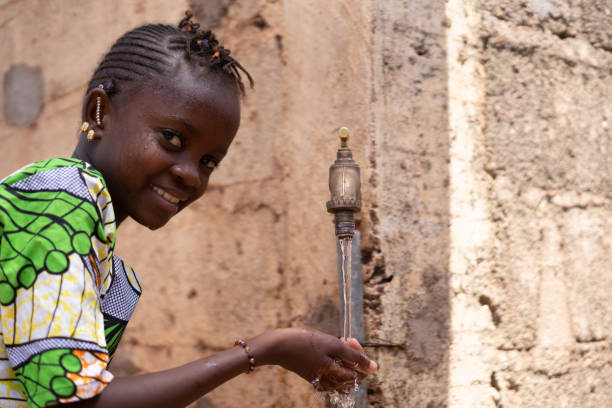 primo primo scatto di un rubinetto con un'etnia nera african girl drinks - africa south africa child african culture foto e immagini stock