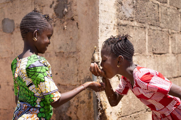 adorable little african girls drinking fresh water from tap - africa south africa child african culture imagens e fotografias de stock