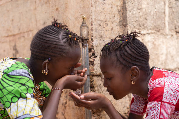due ragazze donne bevono acqua dolce per essere sani - africa south africa child african culture foto e immagini stock