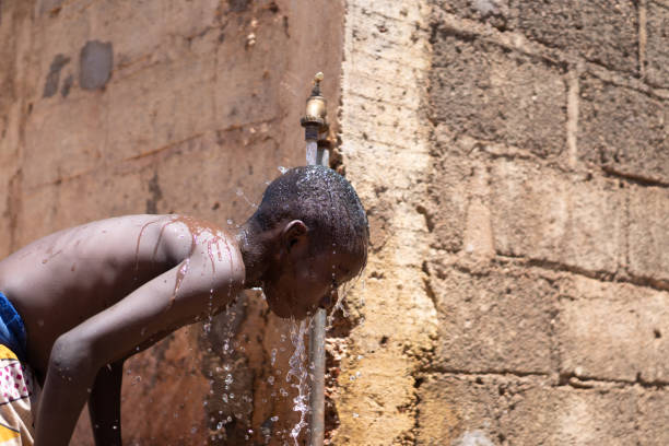 istock Hygiene symbol, African black boy washing under tap 1226010115