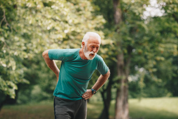 istock Sporty senior man having back pain while jogging. 1226010210