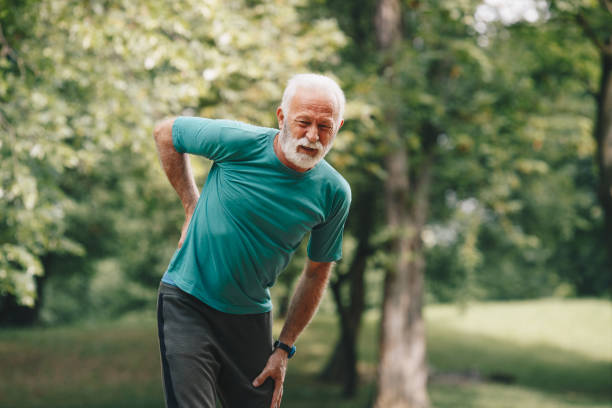 istock Sporty senior man having back pain while jogging. 1226010217
