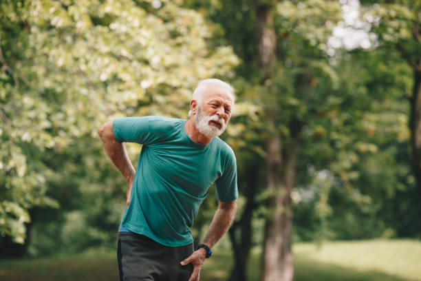istock Sporty senior man having back pain while jogging. 1226010232