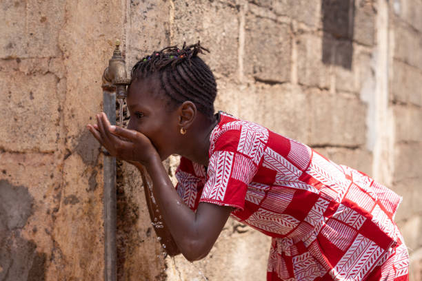 little black girl drinks water outdoors - africa south africa child african culture imagens e fotografias de stock