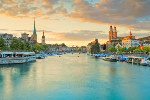 glorioso atardecer a lo largo del horizonte de limmat en zúrich, suiza - grossmunster cathedral fotografías e imágenes de stock