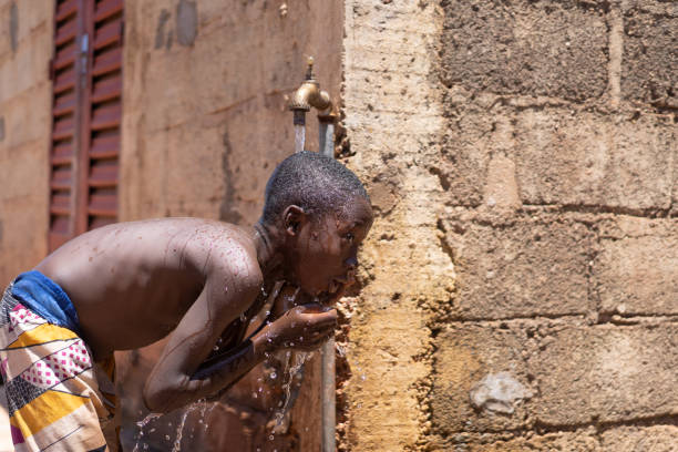 istock African child Washes Himself under Tap Water 1226011112