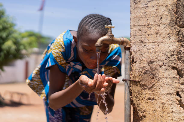 ehrliches bild von afrikanischen schwarzen mädchen trinkwasser bamako mali - thirld world stock-fotos und bilder