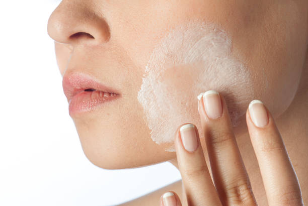 istock Woman applying cream on face 1226013830