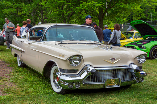 Moncton, New Brunswick, Canada - July 9, 2016 : 1957 Cadillac Sedan DeVille parked in Centennial Park during 2016 Atlantic Nationals, Moncton, New Brunswick, Canada. People walk in the park among the classic cars on display.