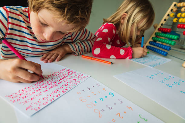 istock boy and girl writing numbers, kids doing homework 1226021016