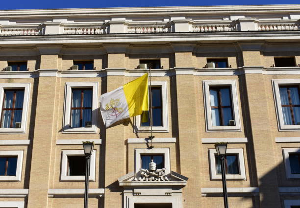 edificio con la bandiera del vaticano e dello stemma vaticano vicino a piazza san pietro. roma, italia. - st peters square foto e immagini stock