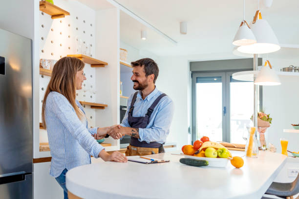 istock Smiling lady thanking repairman for a work 1226023557