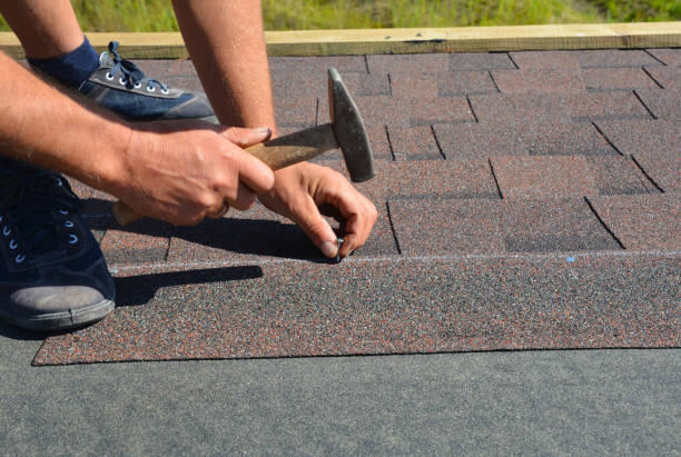 istock Roofer installing Asphalt Shingles on house Roofing Construction with hammer and nails. Roofing Construction. Roofing Contractor laying Asphalt Shingles roof tiles. 1226027146