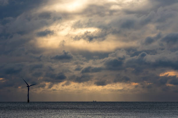istock Dark dramatic sky over sea horizon landscape with wind turbine 1226027304