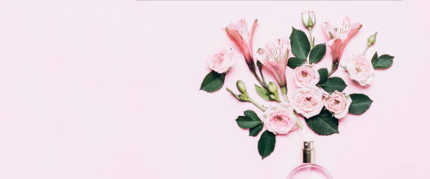 istock Women's perfume bottle and roses flowers on pink background. Banner format with copy space 1226038104