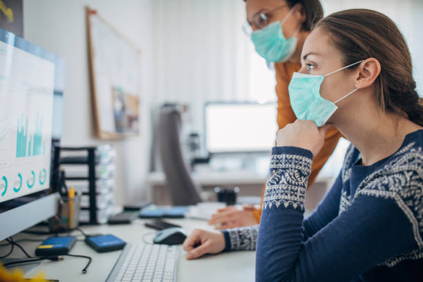 istock Two women working in office with protective masks, to protect themselves against coronavirus 1226038912
