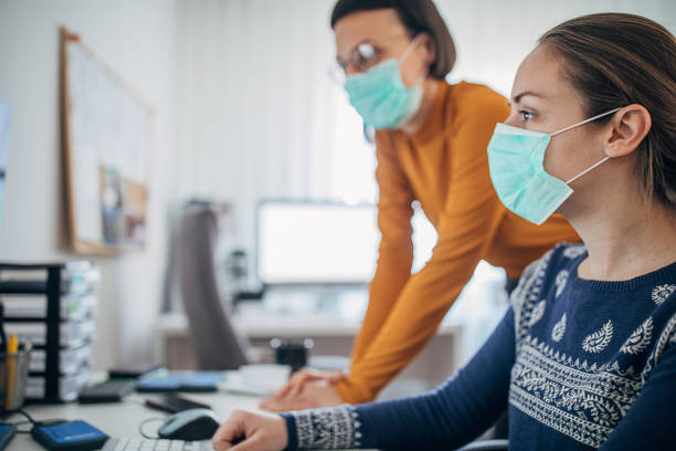 istock Two women working in office with protective masks, to protect themselves against coronavirus 1226038951